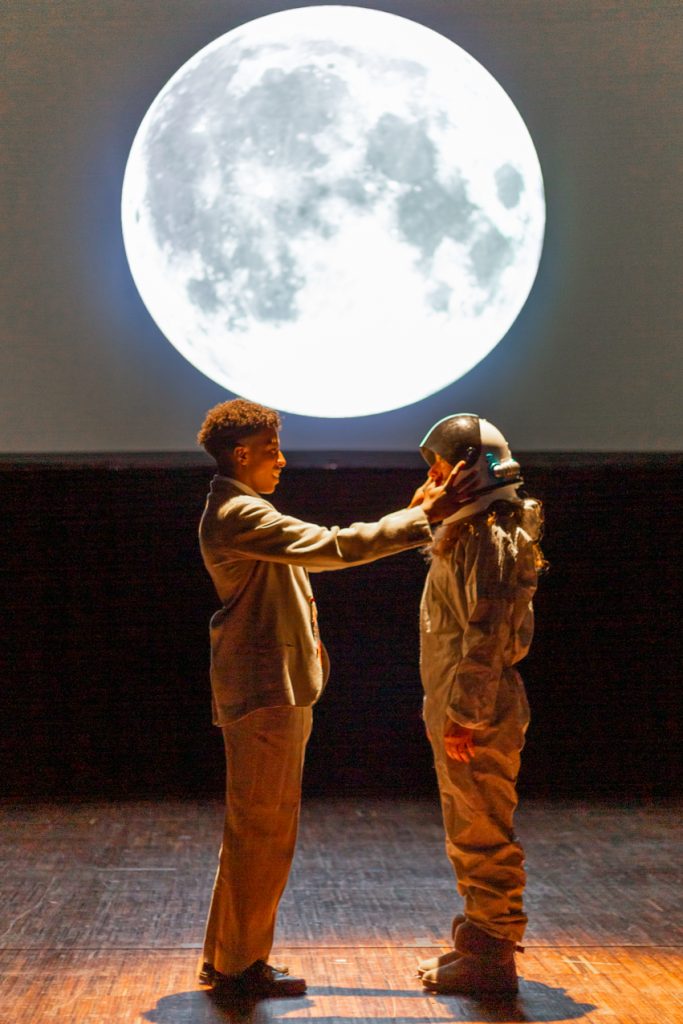 couple en tenue de cosmonaute face a la lune
